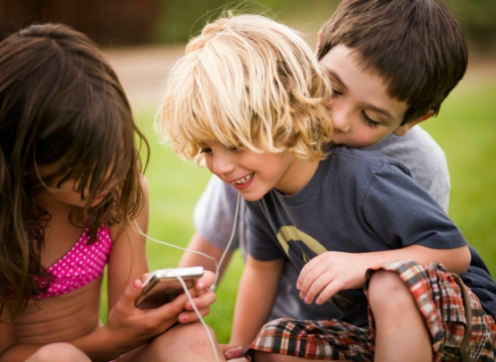 Children listening to earphones outdoors