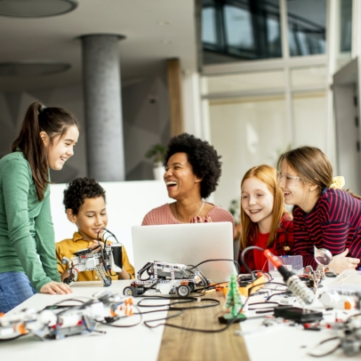 Group of happy kids with their African American female science teacher