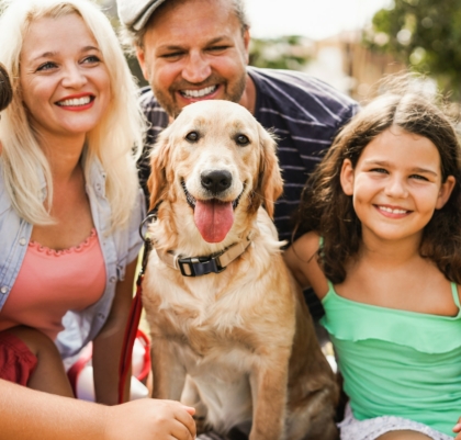 Happy family having fun with children and their dog outdoor summer time - Main focus on dog face